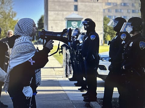 Protesters chant in front of a line of Wayne State police officers shortly after university authorities removed a pro- Palestinian encampment from campus.